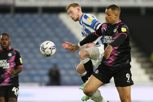 Jonson Clarke-Harris of Peterborough United in action with Lewis O'Brien of Huddersfield Town. Photo: Joe Dent/theposh.com.