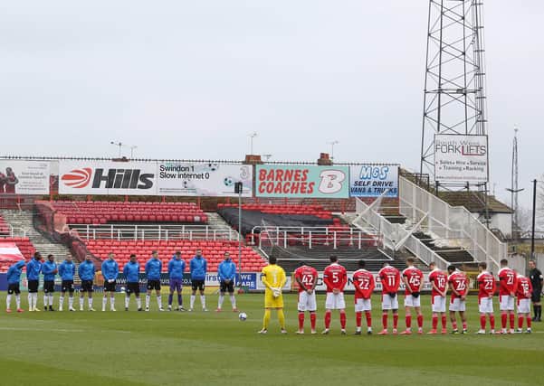 Peterborough United and Swindon Town players stand together for a two minute silence to remember HRH Prince Phillip, Duke of Edinburgh. Photo: Joe Dent/theposh.com.