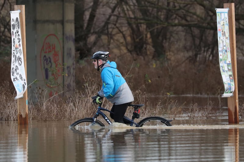 A person cycles through floodwater at Orton as the area is completed flooded as the River Nene burst its banks in Peterborough, earlier this year. Picture: Paul Marriott Photography