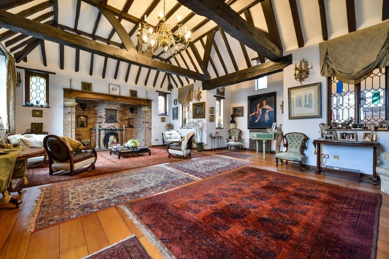 The drawing room is an impressive addition to this house, with a double height vaulted ceiling with exposed wood beams, diamond shaped leaded light windows, stained glass and a large inglenook style fireplace with original wooden mantle with gargoyle carvings as well as a beautiful solid oak wood floor.