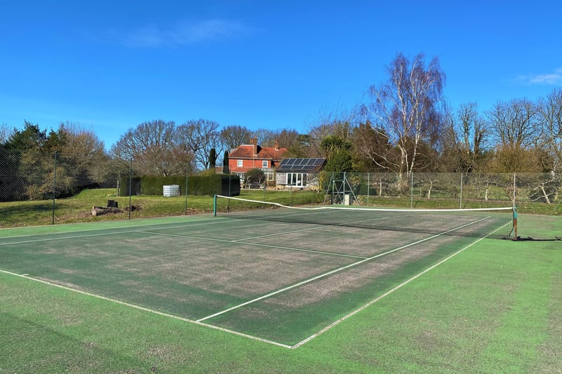 The grounds also include a tennis court (pictured), a four-acre paddock and a wildflower meadow
