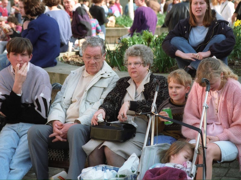 Do you know any of the people sitting near the flower beds?