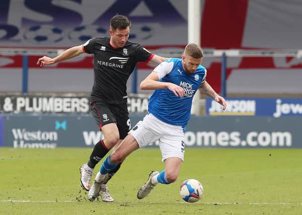 Mark Beevers of Peterborough United in action with Tom Hopper of Lincoln City. Photo: Joe Dent/theposh.com.