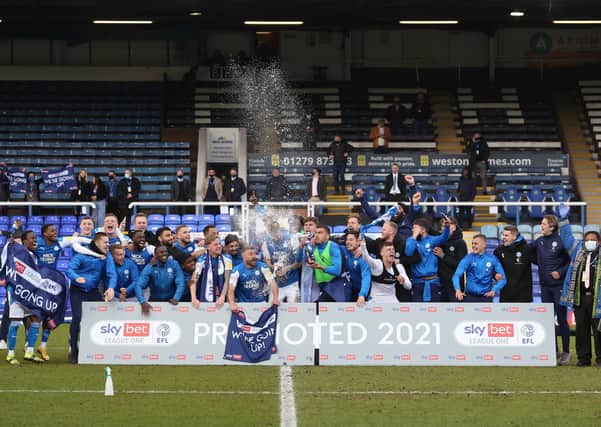Posh players celebrate promotion to the Championship on the pitch after the thrilling 3-3 draw against Lincoln. Photo: Joe Dent/theposh.com.