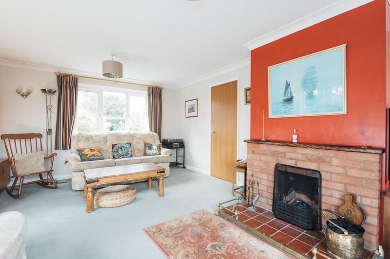 The triple aspect sitting room has a feature fireplace and glazed sliding doors to the rear garden.