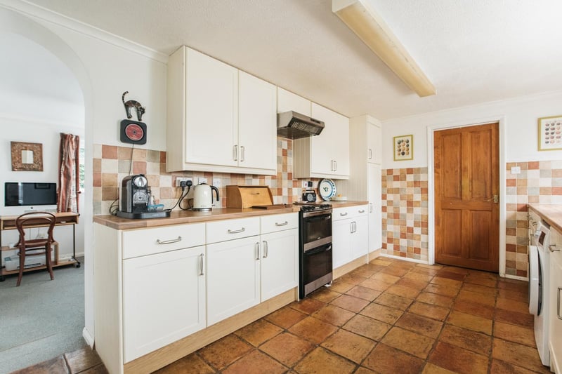 The kitchen has a modern range of cream Shaker style units with complementary work surfaces, an integrated dishwasher and plumbing for a washing machine. Windows overlook the garden at the side and doors lead to a porch and utility room, both of which have doors to the rear garden.