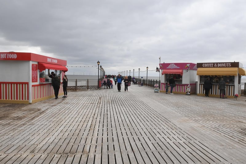 Visitors taking a stroll down the Skegness Pier deck with its new lighting.