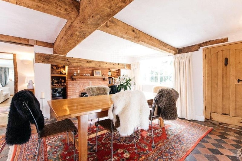 Wooden beams and a brick fireplace create a family room filled with warmth and character