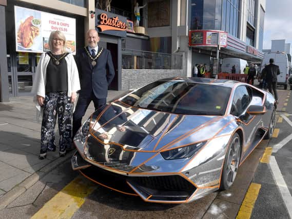 Mayor and Mayoress of Skegness Coun Trevor and Jane Burnham stand by the Lamborghini befire it is hoisted into the new Supercar VIP Lounge in Skegness.