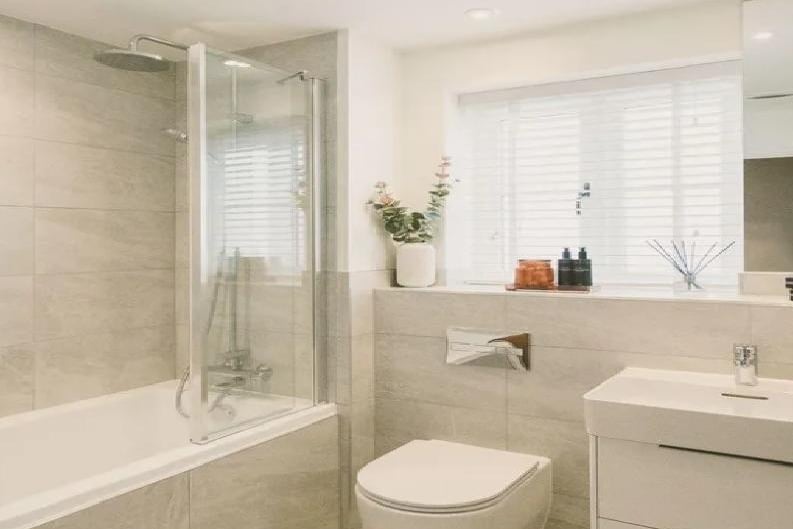 The family bathroom has a contemporary white suite and Minoli ceramic wall. As well as a bath that doubles as a shower, wash basin and heated towel rail.