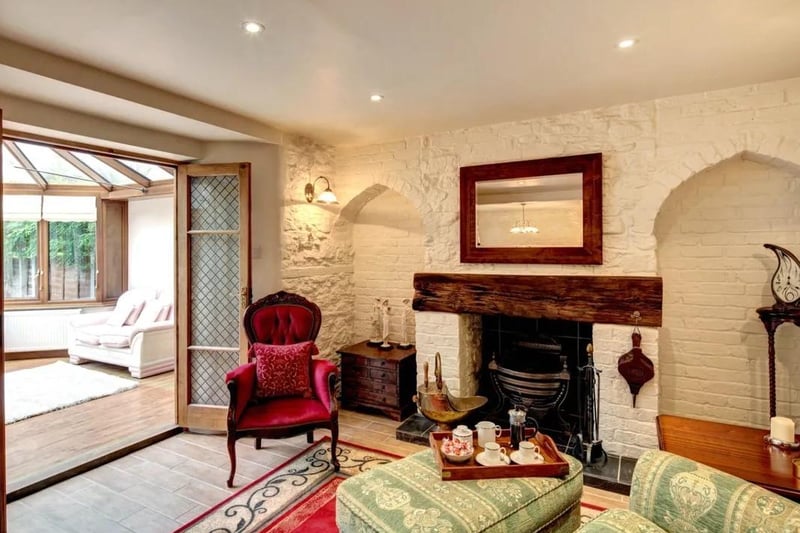 The spacious lounge and snug area with feature fireplace, leading to the conservatory