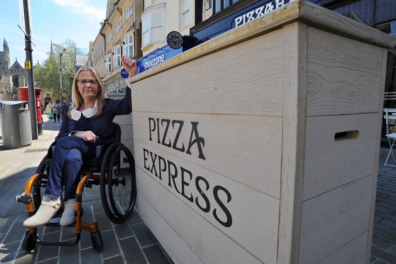 Julie Fernandez showing how items from Pizza Express are the same colour as floor paving, which is a problem for people with limited mobility