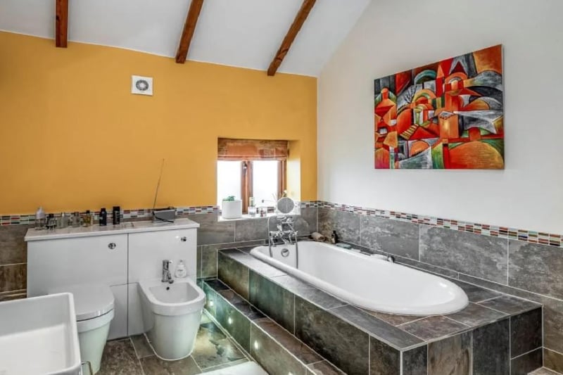One of the communal bathrooms on the property. It has a WC, vanity basin, heated towel rail a grand bath and shower cubicle.