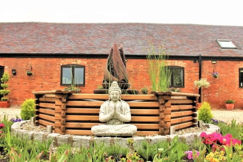 This picturesque courtyard is headlined by a glorious buddhist statue. It highlights the care and time that has been put into designing this converted home.