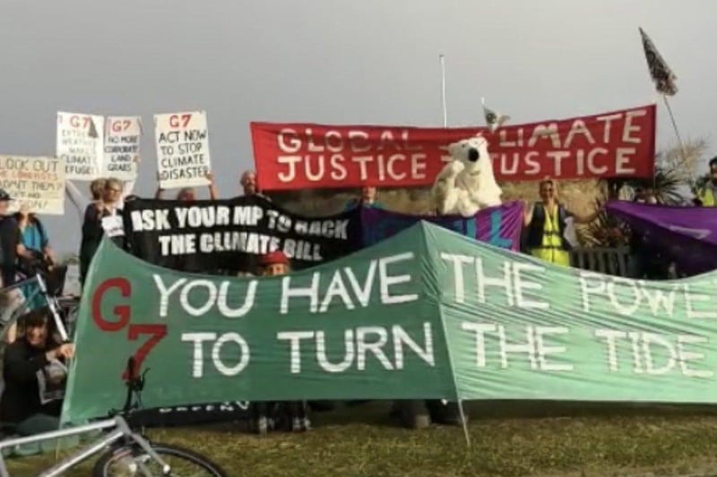 Members from Extinction Rebellion groups hold up signs raising awareness about climate change. SUS-210614-092319001