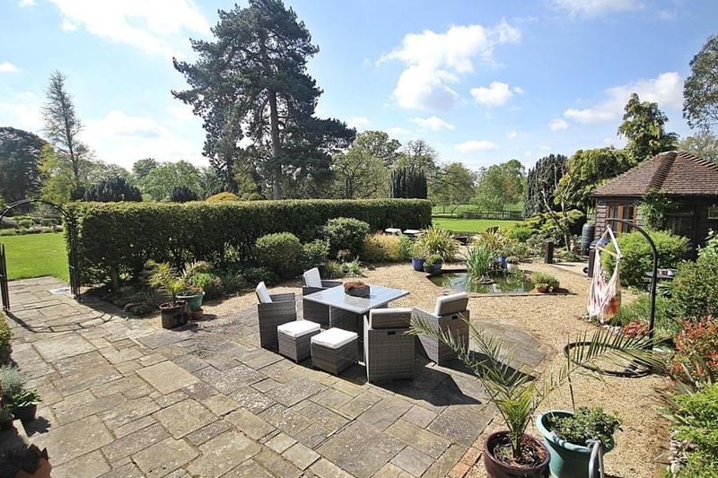 The garden terrace features vast space for entertaining, surrounded by fields