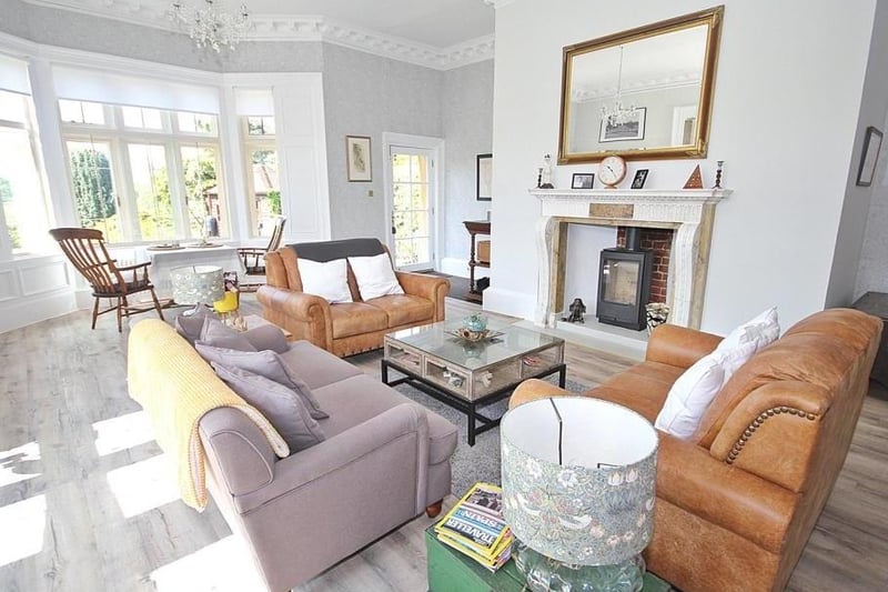 The imposing dual aspect drawing room has bay windows and a feature marble fireplace