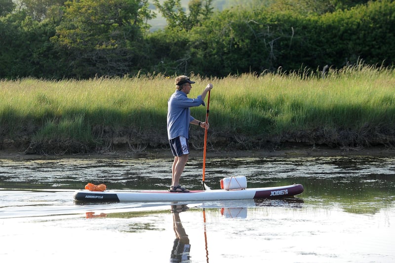 A man paddleboarding on Cuckmere River. (Photo by Jon Rigby) SUS-210616-102836001