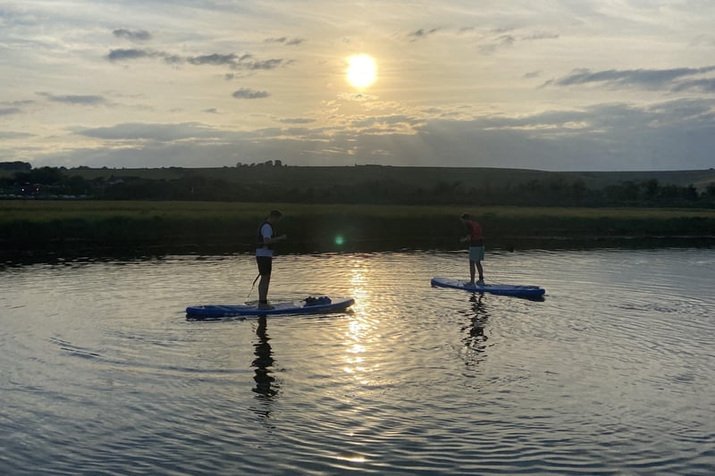 Chris and Jacob paddleboarding on the river as the sun set. SUS-210615-131149001