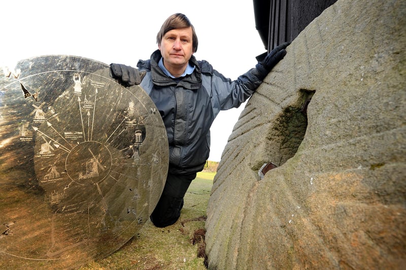 Simon Potter with one of the two remaining mill stones at Jill windmill, and the commemorative plaque removed from a stone that was taken in 2014. Picture: Steve Robards.