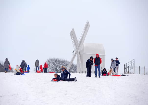 Children have fun playing in the snow near Jack and Jill windmills in January 2013. Photo by Derek Martin.