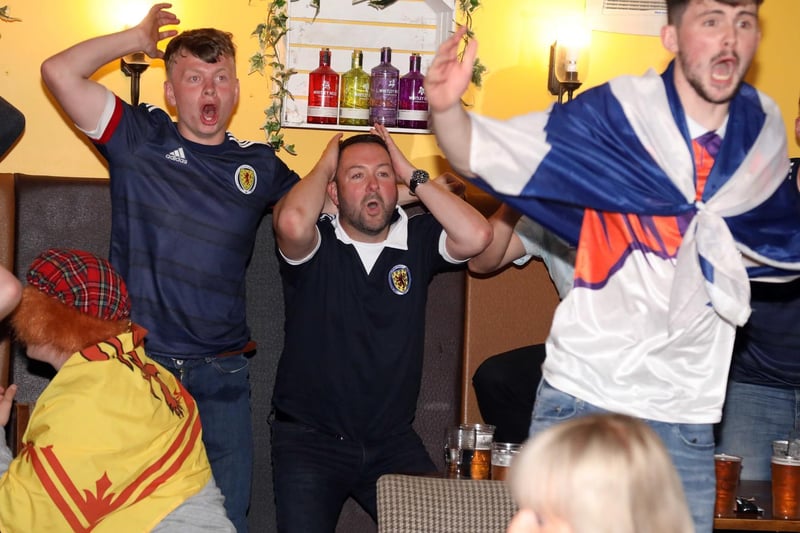 Scotland fans in the Everard Arms watch a near miss