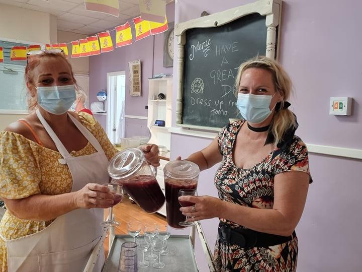 Manger Hayey Peace and Gillian Jackson handing out homemade sangria for Spanish Day.