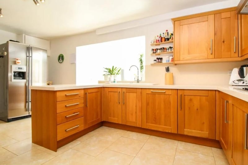 The large kitchen is comprehensively fitted with a range of modern units and ample worktop space