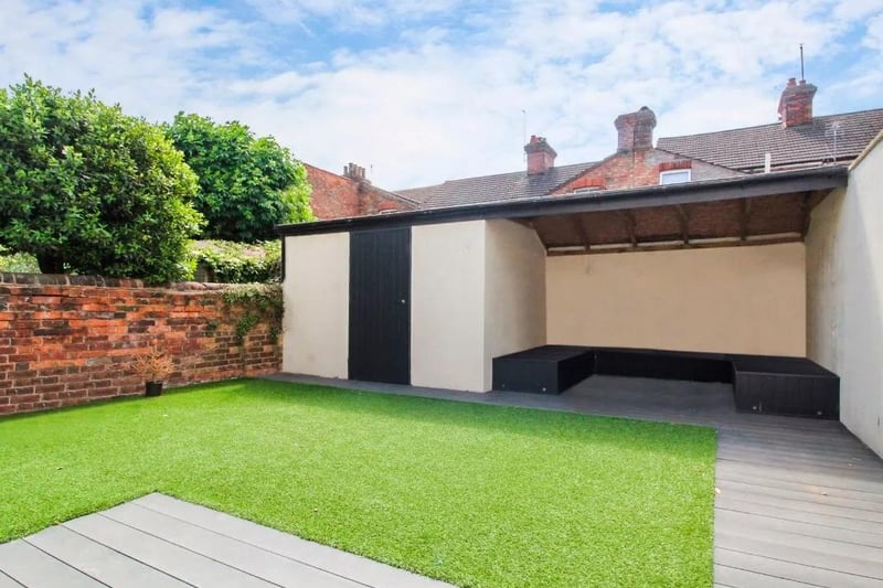 The rear garden with artificial turf and patio/seating area