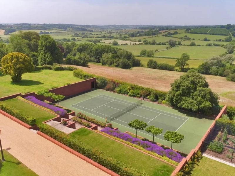 The delightful gardens have both formal elements, with terraced lawns, mellow stone paths and steps with brick retaining walls forming a backdrop for the colourful flowerbeds, and informal areas with shrubs and ornamental/specimen trees.