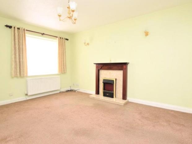 The modest-sized living room comes with a fire place