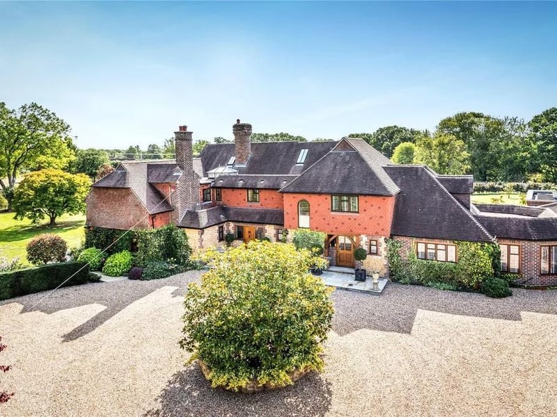 This six-bed detached house in Tismans Common, Rudgwick is a truly exceptional country house, constructed in the early 1900s in the Arts & Crafts style and which in recent years has undergone extensive remodelling, renovation and enlargement to the highest standards, creating a luxurious home of over 7,000 square feet.
It has a conservatory and orangery with wine cellar, tennis pavilion and tennis court and stunning landscaped gardens and grounds.
The guide price is £3,750,000