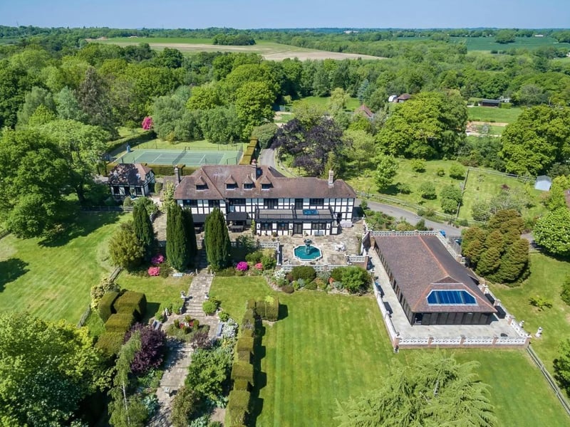 This nine-bed house in Pickwell Lane, Bolney, has been sympathetically extended over the years, and is accessed via three electric gates, one to either end of the sweeping driveway and the other with access to the outbuildings and walled garden.
It has a swimming pool, tennis court, woodland and a paddock, and has a guide price of £5,500,000.
