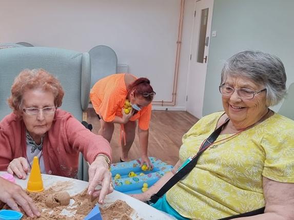 Dylis Peacock and Pat Blundell making sand castles.