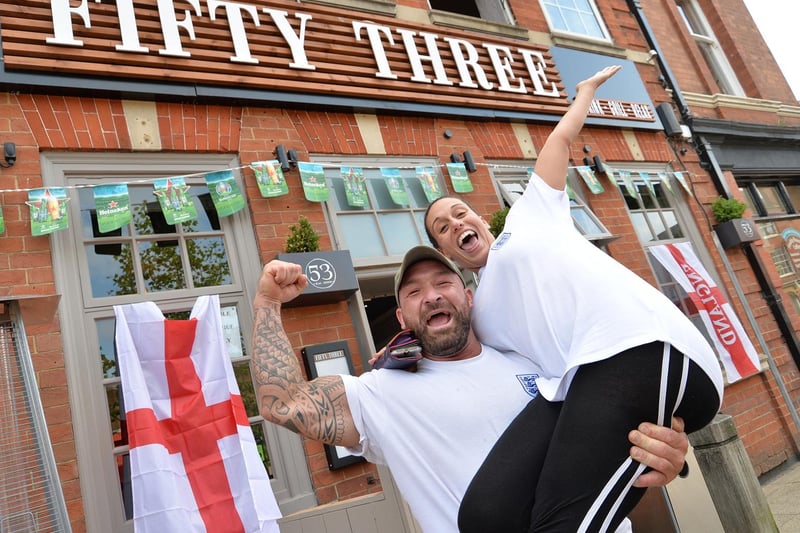 Aaron Lyle and Monira Samir-Kordy celebrate England's victory against Germany outside Fifty Three in Market Harborough.