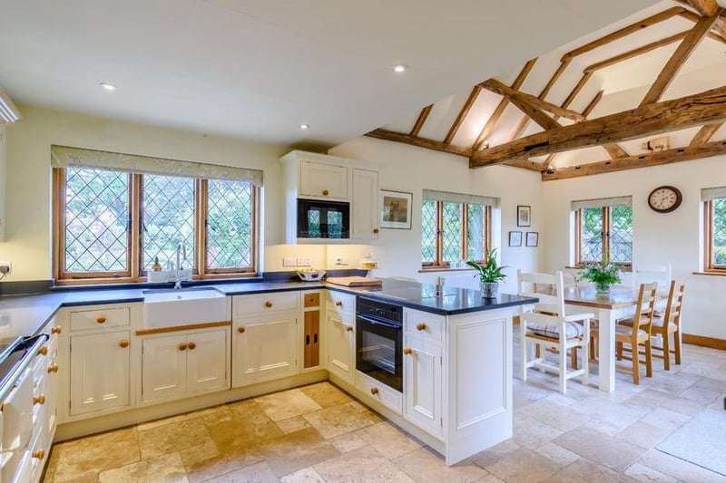 The contemporary kitchen has a travertine tiled floor that extends through to the breakfast room and utility room