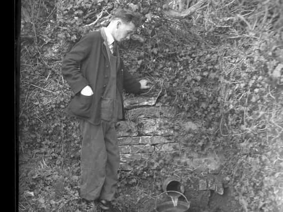 Mr Dilks fetches water from the stream in Dodford.