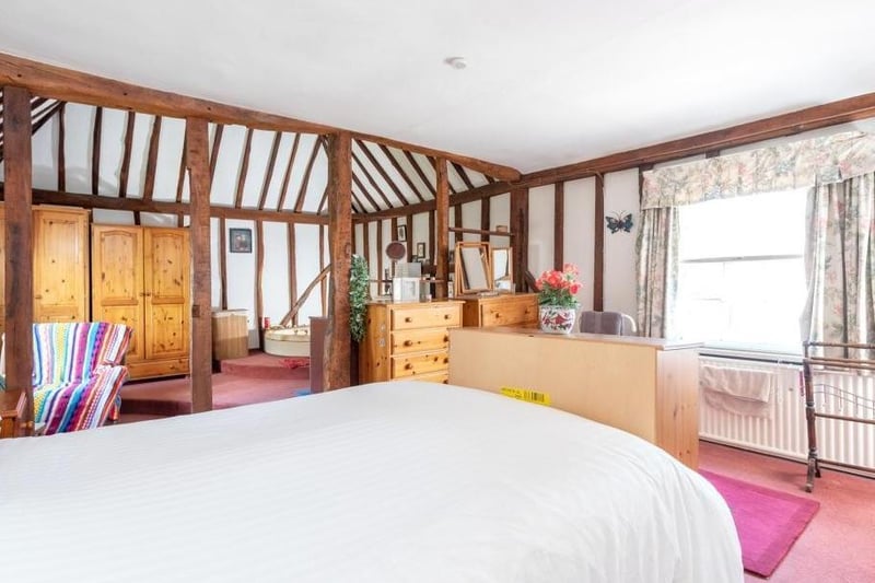 This beautiful wood-beamed master bedroom shows off the history of the house