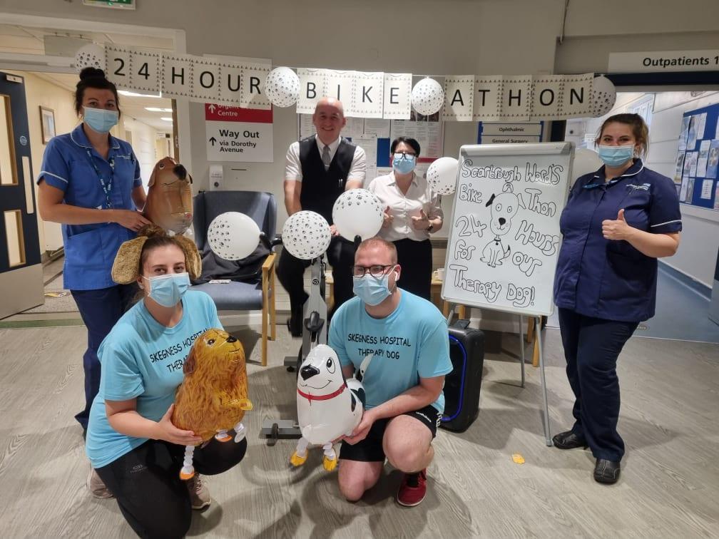 Hospital staff who took part in the 24-hour cycle with Steven Smith, Funeral Services Operative with Frank Wood Funeralcare on the bike and funeral director 
Sarah Northdurft.