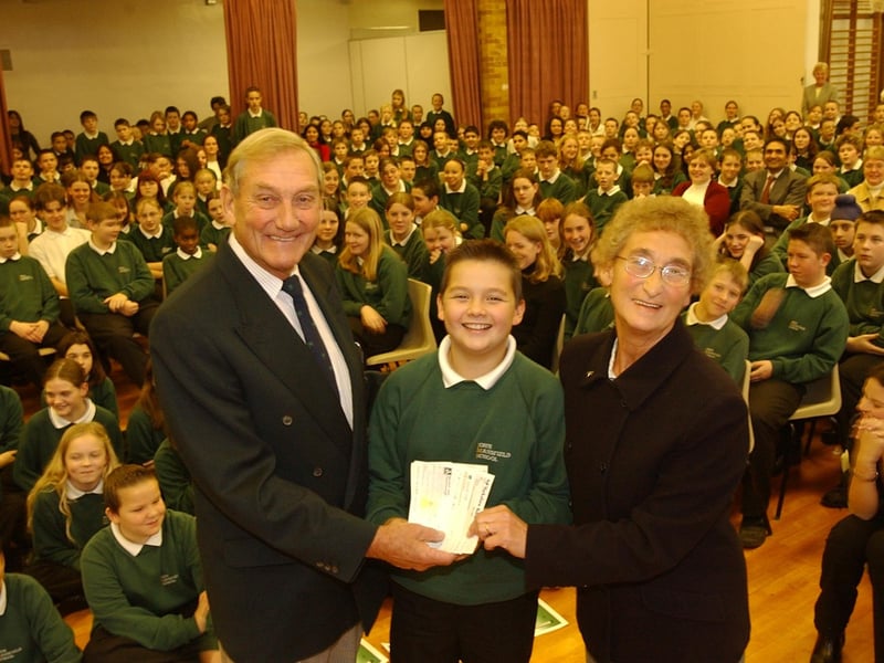 John mansfield pupil Josh Holdship, 11 - who himself raised £118 following the annual Train and Trek event - presents Derek Cole and Pamela Cole with £1000 for the Macmillan Cancer appeal.