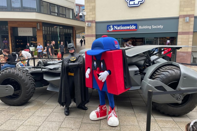 Batman with the Metro mascot in front of the Batmobile
