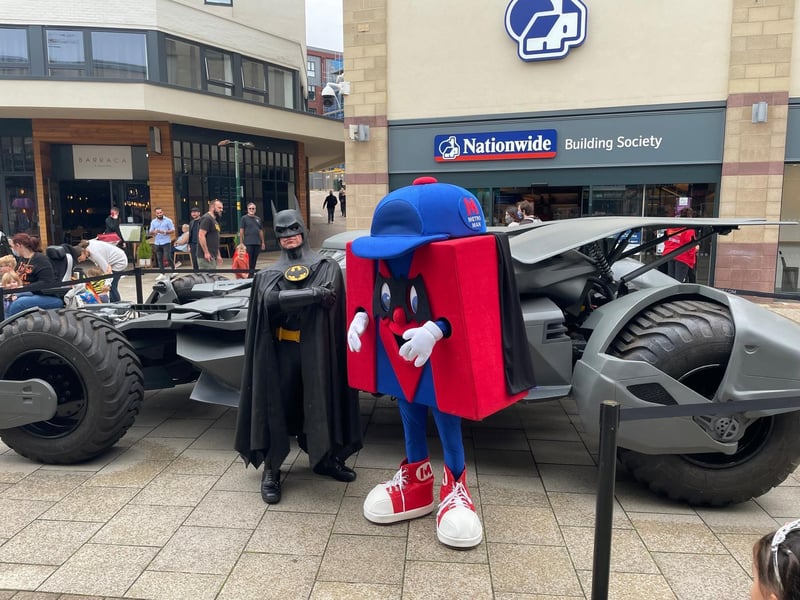 Batman with the Metro mascot in front of the Batmobile