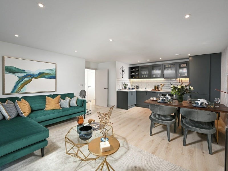 The open plan living room leads to the balcony via French doors