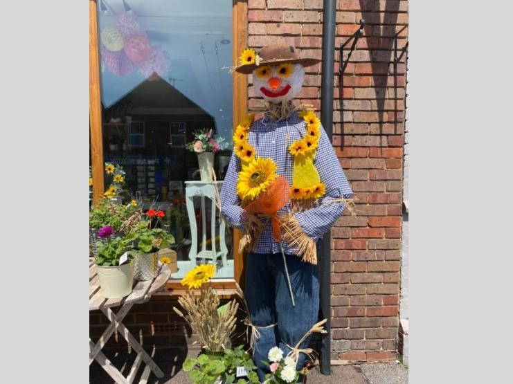 The Florist displayed a scarecrow in the shop window