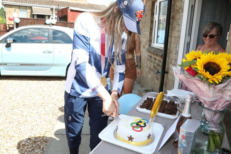 Charlotte cutting the cake decorated with the Olympic rings
