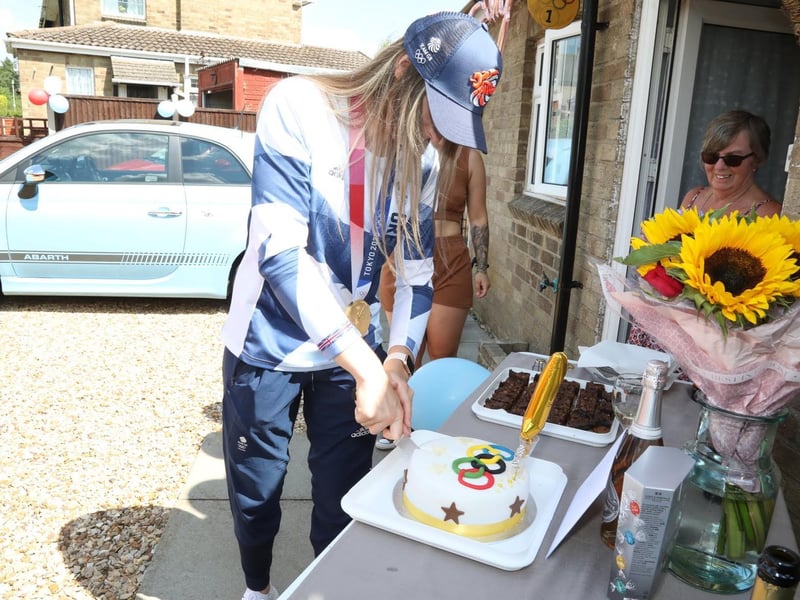 Charlotte cutting the cake decorated with the Olympic rings