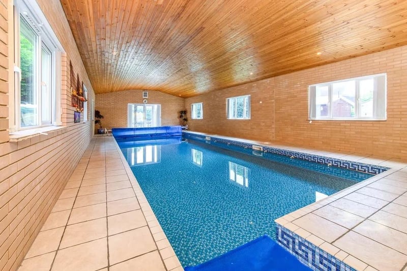 The pool house featuring a heated indoor swimming pool