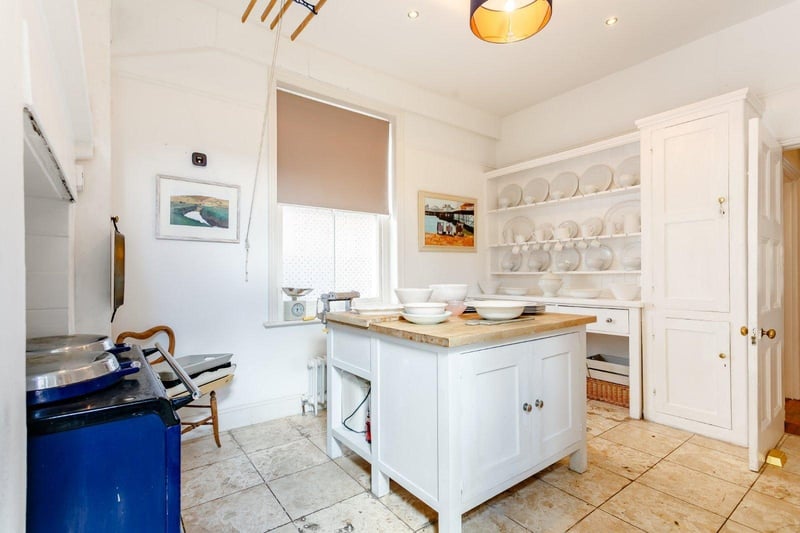The kitchen has an island and an Aga SUS-210817-150440001