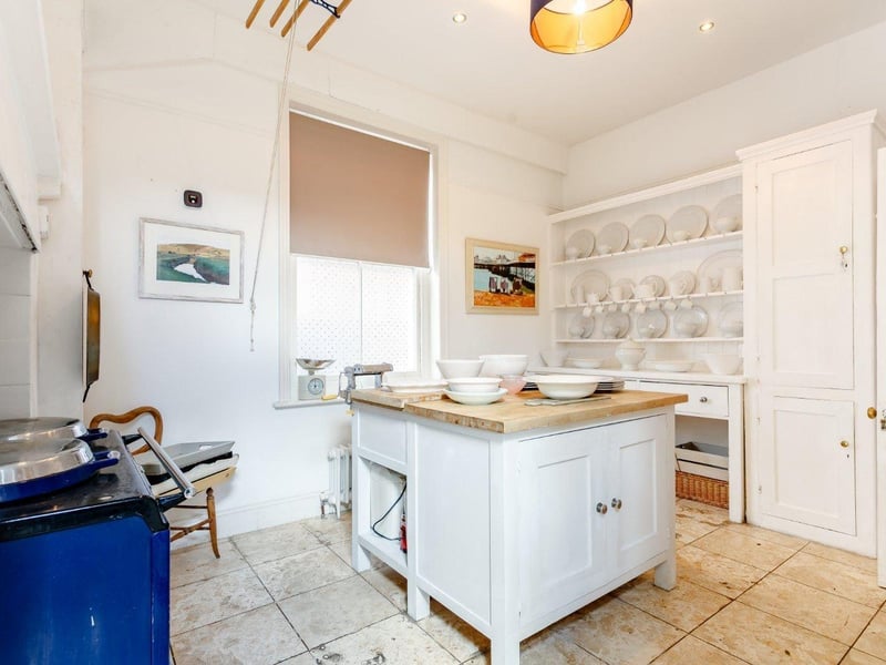 The kitchen has an island and an Aga SUS-210817-150440001