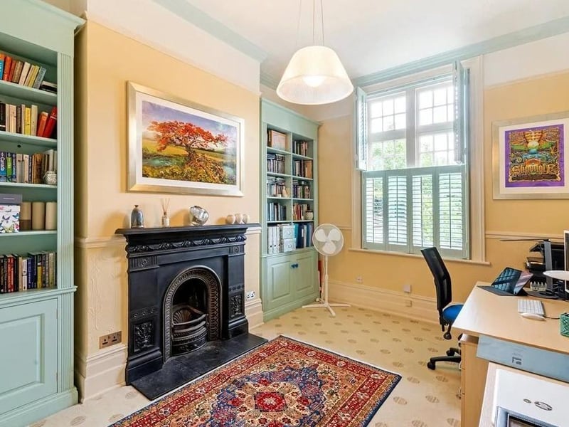 The study has shelves fitted into the alcoves either side of its feature cast iron fireplace. Picture: Savills - Haywards Heath.